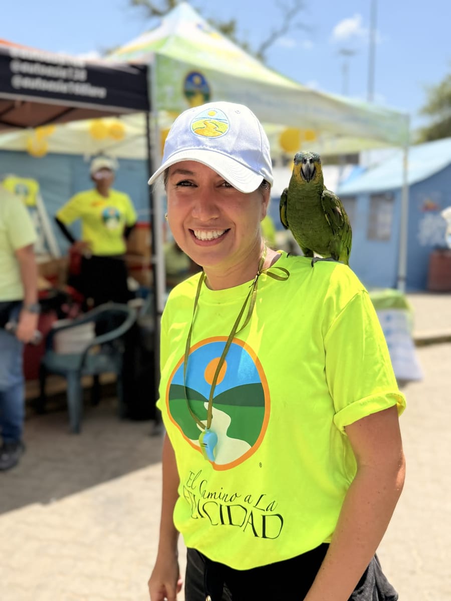 Voluntaria sonriendo con un loro en el hombro en el refugio